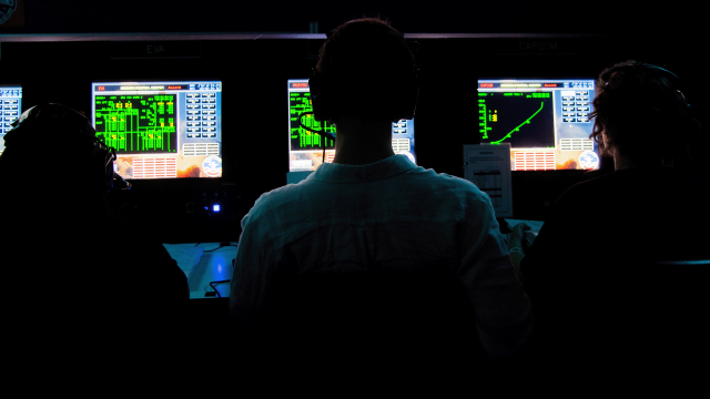 Trainees monitor a simulated space mission from their stations at Mission Control